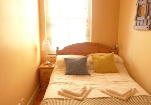 a bedroom with a bed with two pillows and a window at Beach View in North Berwick