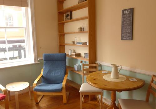 a room with a table and a blue chair at Beach View in North Berwick