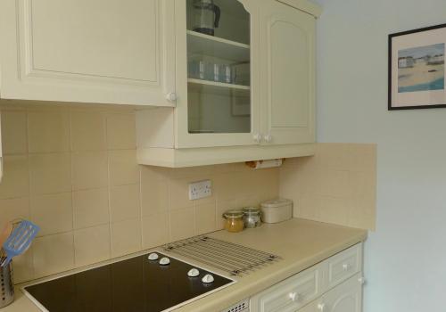 a kitchen with white cabinets and a counter top at Beach View in North Berwick