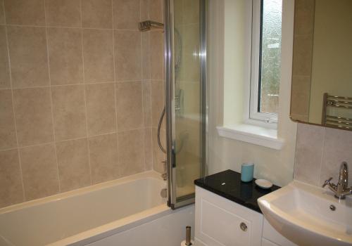 uma casa de banho com um chuveiro e um lavatório. em Callie's Cottage em North Berwick
