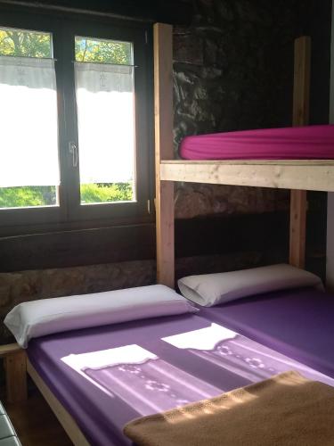 two bunk beds in a room with two windows at Otardi in Asteasu