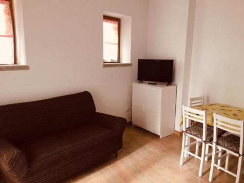 a living room with a couch and a television at CAV Mameli in Dorgali