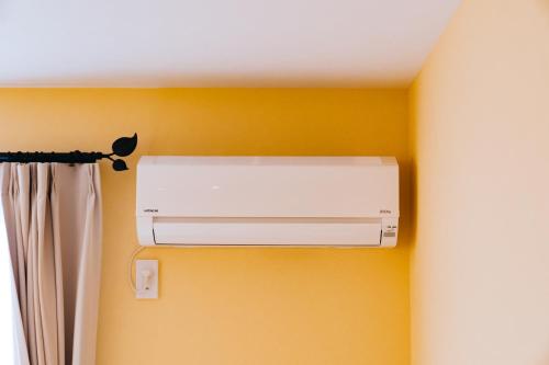a white air conditioner on a wall in a room at FUKUOKA MOJIKO STAY in Kitakyushu