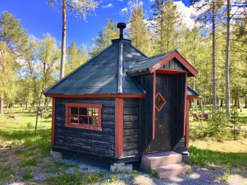 a small log cabin with a black roof at Sörbygården Bed & Breakfast in Brunflo