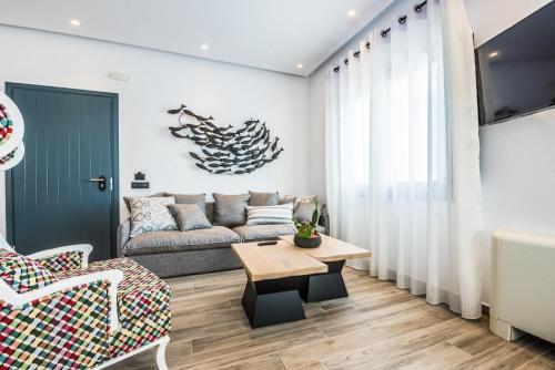 a living room with a couch and a table at Portes Suites & Villas Mykonos in Mýkonos City