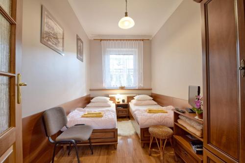 pokój z dwoma łóżkami, stołem i krzesłami w obiekcie Apartament Zuzia w Dźwirzynie