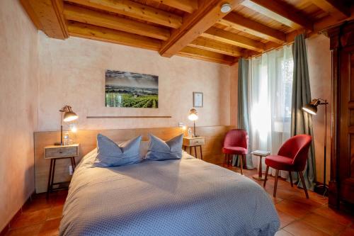 um quarto com uma cama com 2 cadeiras e uma janela em B&B L'Orée du Bois Bourgogne - Adults Only em Saint-Nicolas-lès-Cîteaux