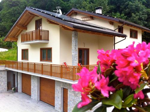 a house with a balcony and pink flowers at Mortirolo in Mazzo di Valtellina