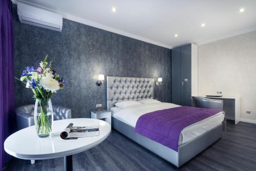 a hotel room with a bed and a table with flowers at Flatlux Apartments in Kyiv