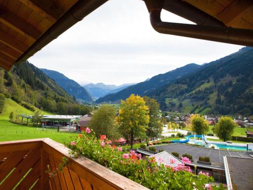 a view of a valley from a balcony with flowers at Landhaus Gastein in Dorfgastein