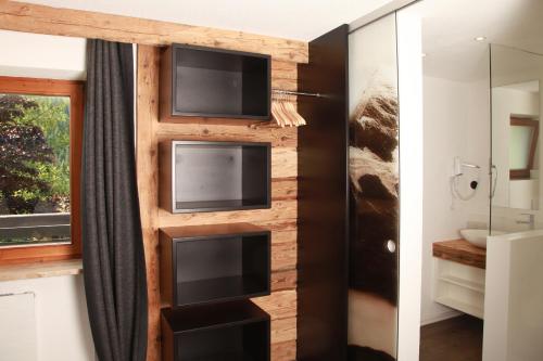 ein Badezimmer mit einer Holzwand und 2 Mikrowellen in der Unterkunft Landhaus Bromm in Riezlern