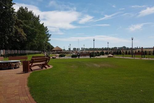 a park with two benches and a picnic table at Hotel Texicana in Sulechów