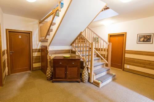a hallway with a staircase with wooden railings at Hotel Admiral in Lipno nad Vltavou