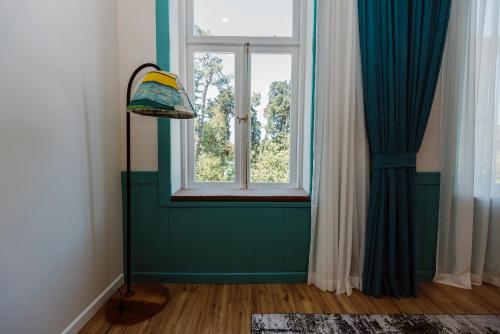 a green room with a window and a lamp at Boulevard Hotel Batumi in Batumi