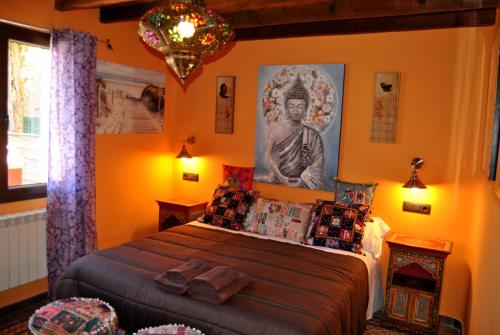 sypialnia z łóżkiem z posągiem na ścianie w obiekcie Complejo Casas Rurales MANSIONES Y VILLAS DELUXE w mieście Collado Mediano