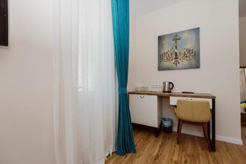 a room with a desk and a blue curtain at Boulevard Hotel Batumi in Batumi