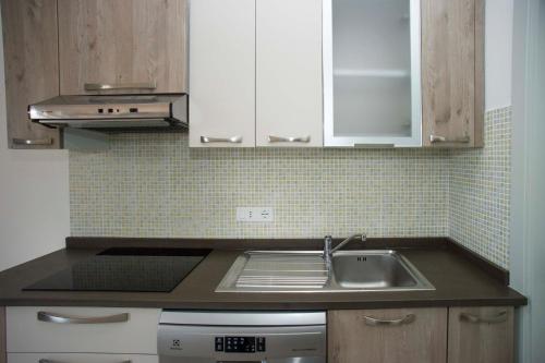 a kitchen with a sink and white cabinets at Il Caubbio in Lacona