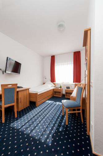 a hotel room with a bed and a desk and chairs at Landhotel Butjadinger Tor in Nordenham