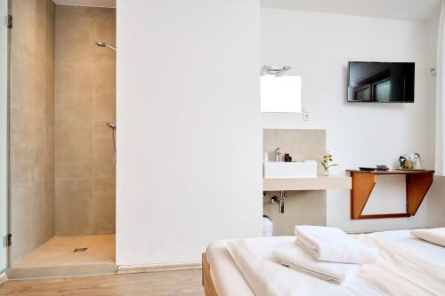 a bathroom with a shower and a bed with towels at Pension Haus am Einberg in Meschede
