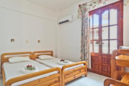 - une chambre avec 2 lits et une fenêtre dans l'établissement Sea Stone Apartments, à Karpathos