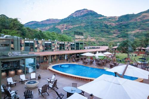 a resort with a swimming pool and mountains in the background at DATA Resort by Della Adventure in Lonavala