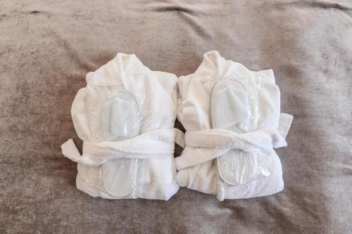 パランガにあるSea View Penthouse Terrace Palanga Old Townのベッドの上に置かれた2組の白いタオル