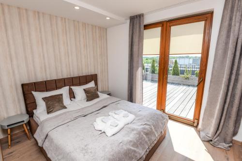 パランガにあるSea View Penthouse Terrace Palanga Old Townのベッドとタオル2枚のある寝室