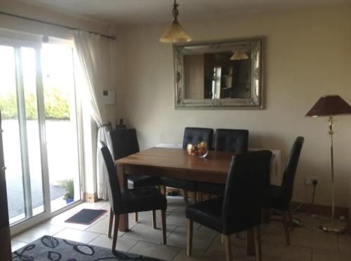 a dining room table with chairs and a mirror at Eden House in Carlingford