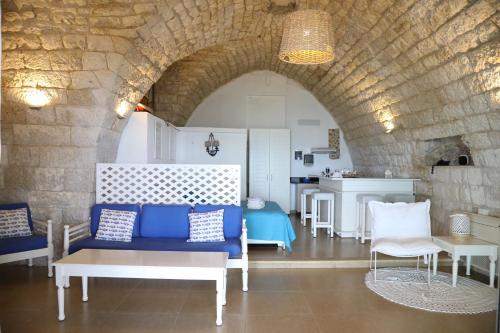 a living room with a blue couch and a table at Le Blanc Bleu in Jbeil