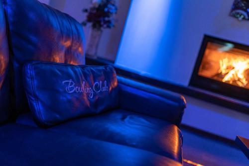 a leather couch in a living room with a fireplace at BNC Hotel - Restaurant - Bowling in Bratislava