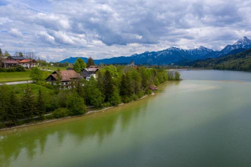 an aerial view of a lake with houses and mountains at Seehotel Weissensee in Füssen