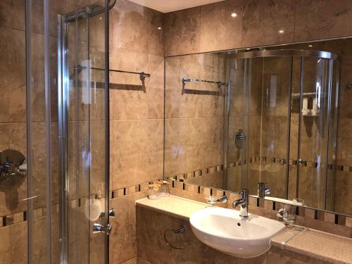 a bathroom with a sink and a glass shower at The Anchor Ely in Ely