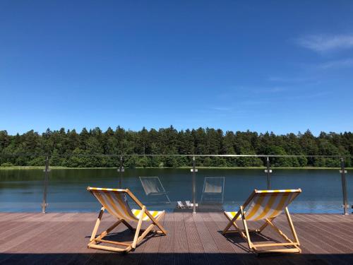 two chairs sitting on a dock next to a lake at Krokodyl Sport&Spa in Mielno