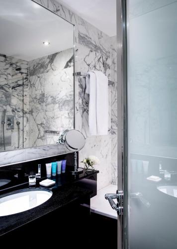 a bathroom with a tub and a sink and a mirror at The Bloomsbury Hotel in London