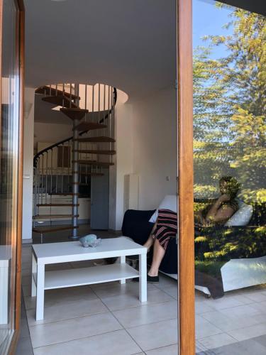 a woman sitting on a couch in a living room at Krokodyl Sport&Spa in Mielno