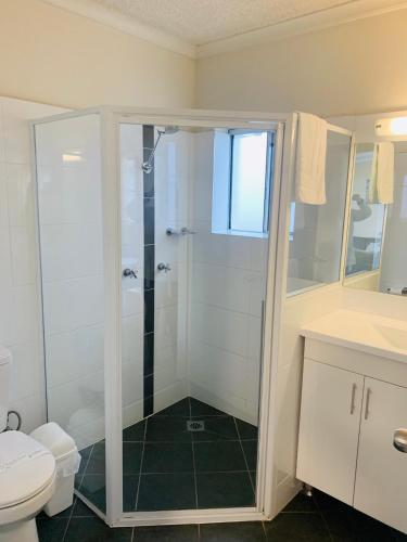 a bathroom with a shower and a toilet at Zorba Waterfront Motel in Batemans Bay