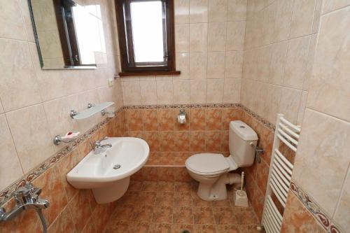 a bathroom with a toilet and a sink at Toncho's Guest House for 16 guests in Arbanasi