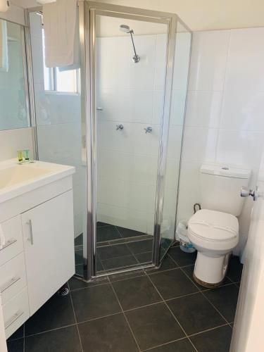 a bathroom with a shower and a toilet at Zorba Waterfront Motel in Batemans Bay