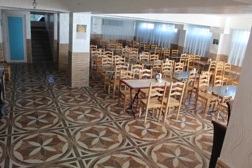 a dining room with tables and chairs on a patterned floor at Hotel Georgia in Gonio