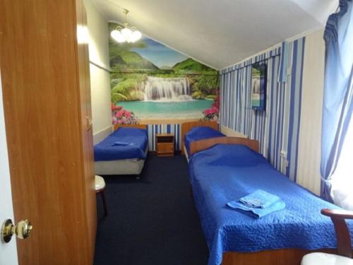 Cette chambre comprend deux lits et une peinture représentant une cascade. dans l'établissement Hotel Lotos, à Irkoutsk
