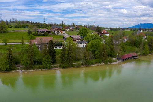 an aerial view of a house next to a lake at Seehotel Weissensee in Füssen