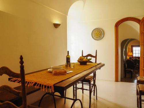 ein Esszimmer mit einem Tisch und einer Flasche Wein in der Unterkunft Relais Euterpini in Pantelleria