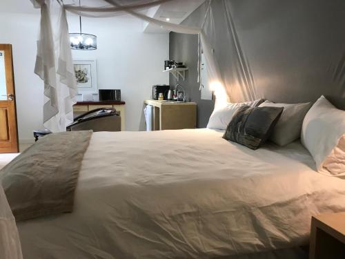 a bedroom with a large white bed with pillows at Bryan's View in Windhoek