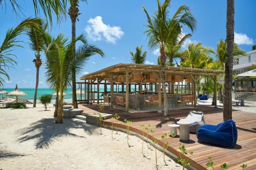 a pavilion on the beach with palm trees and the ocean at Lagoon Attitude (Adults Only) in Cap Malheureux