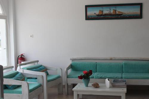 a living room with a green couch and two chairs at Londos Hotel in Piso Livadi