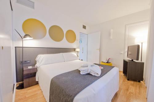 a bedroom with a bed with a towel on it at Aparthotel Atenea Valles in Granollers
