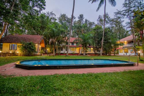 a swimming pool in the yard of a house at Orchid Trails Resort in Sultan Bathery