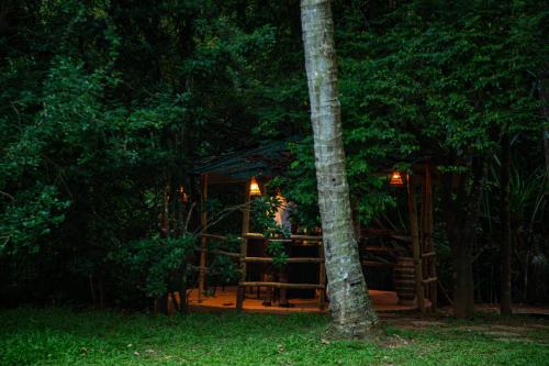 a tree house in the woods at night at Orchid Trails Resort in Sultan Bathery
