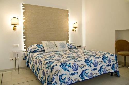 a bedroom with a bed with a blue and white comforter at Fortino B&B Capri in Capri