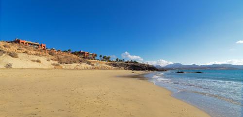 
a sandy beach with a view of the ocean at H10 Tindaya in Costa Calma
